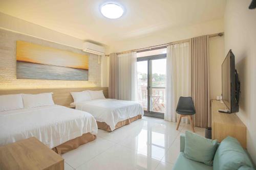 a hotel room with two beds and a television at 里舍民宿 in Jincheng