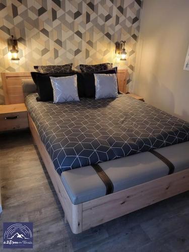 Un dormitorio con una cama en una habitación con una pared. en Hébergement avec SPA privatif, en Loos-en-Gohelle
