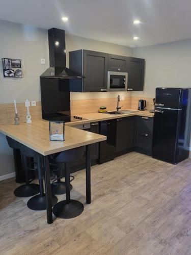 une cuisine avec une table en bois et un réfrigérateur dans l'établissement Hébergement avec SPA privatif, à Loos-en-Gohelle