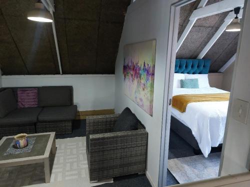 a small room with a bed and a couch at Gallery Guesthouse (La Sky Villa) in Gqeberha