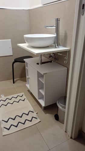 a bathroom with a white sink and a rug at IL CORTILETTO in Bari