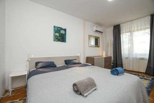 a bedroom with a large bed with a gray blanket at Villa Mina Kladovo, entire charming house with 5 bedrooms in Kladovo
