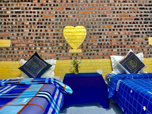two beds in a room with a brick wall at My's Homestay sapa in Sa Pa