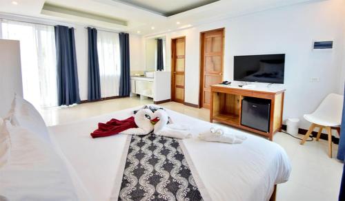 a hotel room with a bed and a tv at The XIMO Suites in Boracay