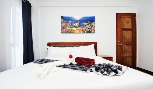 a bedroom with a white bed with towels on it at The XIMO Suites in Boracay