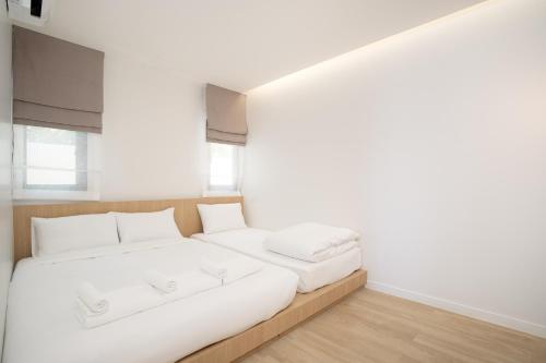 a white bedroom with a large bed with white pillows at The Season Resort in Ban Chamrung