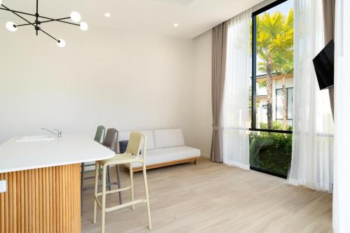 a kitchen and living room with a couch and a window at The Season Resort in Ban Chamrung