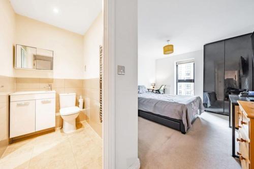 a bedroom with a bed and a toilet and a sink at Luxury Flat in Welwyn Garden City