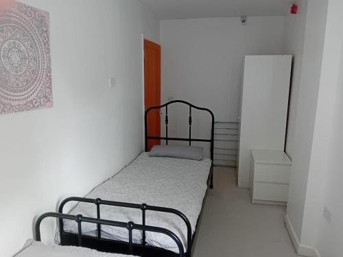 a small bedroom with a bed and a refrigerator at Apartment in Historic Mill, near Dover Port in Kent