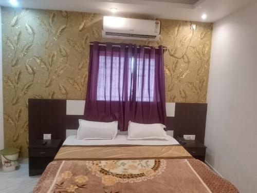 um quarto com uma cama e uma janela roxa em Hotel Alakhraj Palace em Hazārībāg