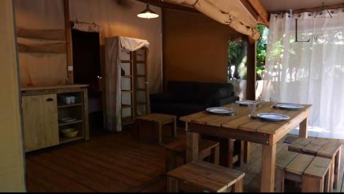 ein Wohnzimmer mit einem Holztisch und einer Küche in der Unterkunft Lodging Le Lac in Lacanau