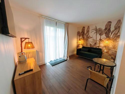un salon avec un canapé vert et une table dans l'établissement Domaine de L'isle Maniere, à Saint-Quentin-sur-le-Homme