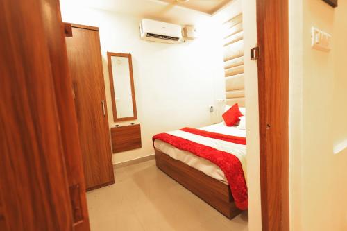a small bedroom with a bed and a mirror at Hotel King City in Muzaffarnagar