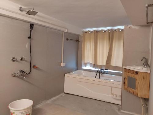 a bathroom with a bath tub and a sink at Ch'i SoulStone Retreat in Sainj