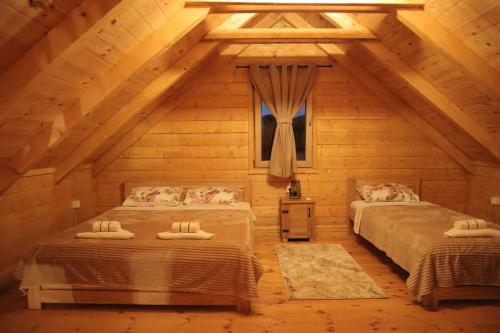 a bedroom with two beds in a log cabin at Green Field Apartments in Virpazar