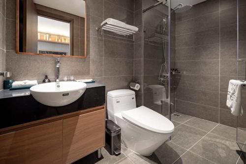 a bathroom with a toilet and a sink and a shower at M Continental by Mandala Bac Giang in Bắc Giang