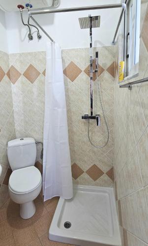 a bathroom with a toilet and a shower at Joen Apartments in Sarandë