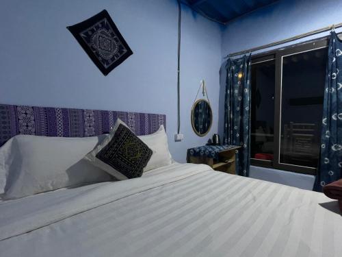 My's Homestay sapa في سابا: غرفة نوم بسرير وملاءات بيضاء ونافذة