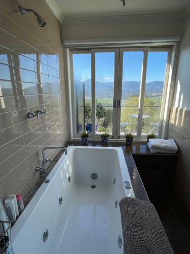 a bathroom with a bath tub with a large window at Beauty of Healesville in Healesville