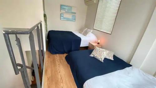 two beds in a small room with a staircase at Good Space Hotel Yoyogi in Tokyo