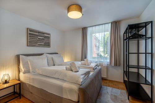 duże łóżko w pokoju z oknem w obiekcie Stadtapartment Luna by Cosy Homes w Villach