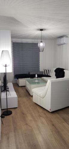 a living room with two white couches and a table at Comfort in Kiseljak