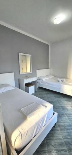 a bedroom with two beds and a mirror at Joen Apartments in Sarandë