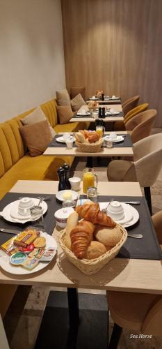 a group of tables with bread and pastries on them at Hotel Des Zouaves in Koksijde