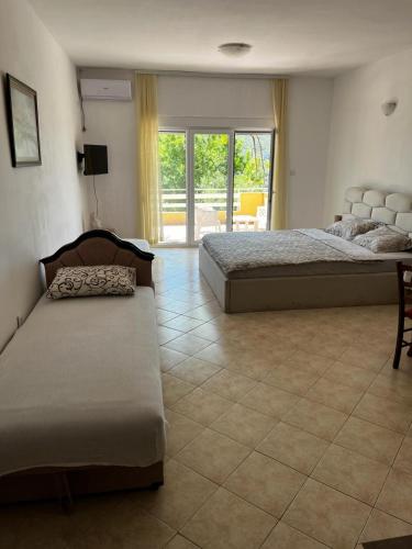 - une chambre avec deux lits et du carrelage dans l'établissement Apartman Perić, à Bigovo