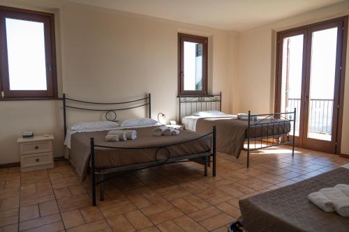a bedroom with two beds and two tables and windows at Villa Fortuna Belvedere in Montegranaro