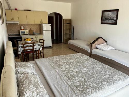 Il comprend un salon avec deux lits et une cuisine avec une table. dans l'établissement Apartman Perić, à Bigovo