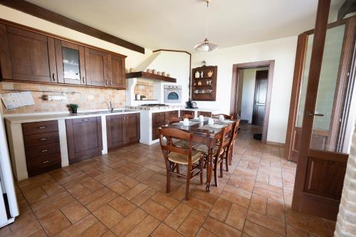 a kitchen with a wooden table and chairs in it at Villa Fortuna Belvedere in Montegranaro