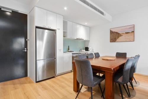 eine Küche und ein Esszimmer mit einem Tisch und einem Kühlschrank in der Unterkunft Port Melbourne Dog Beach Stays in Melbourne