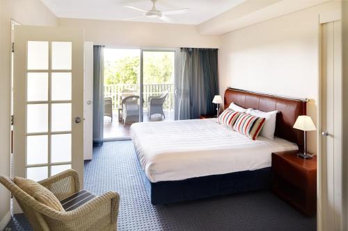 a hotel room with a bed and a balcony at Caves House Hotel Apartments in Yallingup