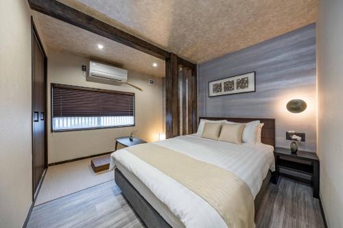 a bedroom with a large bed and a window at JAPAVISTA Hisho in Osaka
