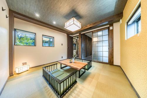 a dining room with a wooden table and benches at JAPAVISTA Hisho in Osaka