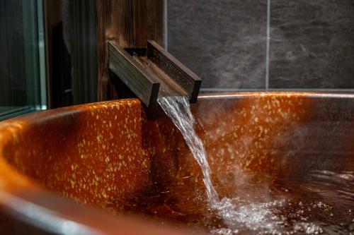 a copper bathroom sink with a water fountain at JAPAVISTA Hisho in Osaka