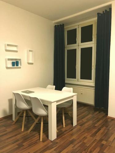 - une table et des chaises blanches dans la chambre dans l'établissement 750 SFT Lovely Apartment in Central Berlin Mitte, à Berlin