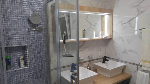 a bathroom with a sink and a shower with a mirror at 100sqm comfort free parking Airport 10min in Thessaloniki