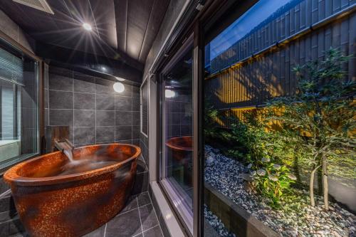 a bathroom with a copper tub in a window at JAPAVISTA Hisho in Osaka