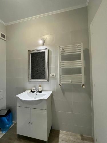 ein weißes Bad mit einem Waschbecken und einem Fenster in der Unterkunft Universitatii Rooms in Oradea