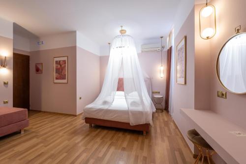 a bedroom with a bed with a canopy at L Suites The Writer's House in Gythio