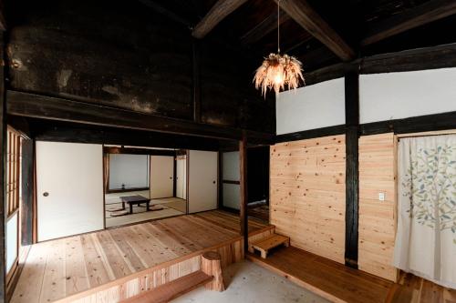 Habitación vacía con suelo de madera y lámpara de araña. en Casa de Mano - Vacation STAY 21638v, en Mihara