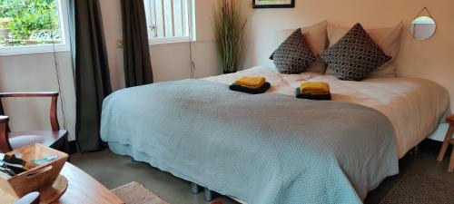 1 dormitorio con 1 cama grande y 2 toallas. en Ecolodge prive sauna, prachtige tuin, jacuzzi en warm zwembad, en Tilburg