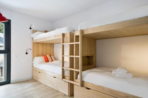 two bunk beds in a room with white walls at LUDERNA - Apartamento Espiargo in Garós