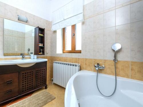 a bathroom with a bath tub and a sink at Villa Wish Comfortable holiday residence in Čabrunići