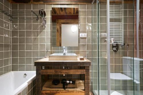 a bathroom with a sink and a tub and a mirror at LUDERNA - Apartamento Pin Roi in Salardú