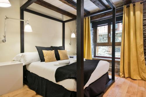 a bedroom with a black and white bed and a window at LUDERNA - Apartamento Pin Roi in Salardú