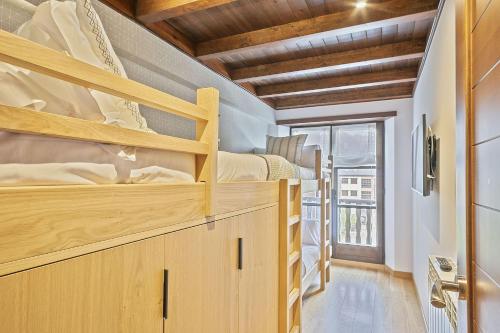 a room with two bunk beds and a window at Luderna - Apartamento Val de Ruda A14 Montoliu in Baqueira-Beret