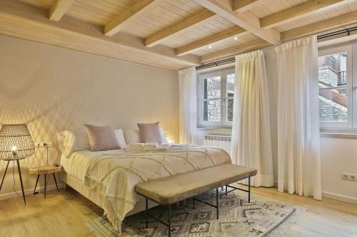 a bedroom with a bed and two windows at Luderna - Apartamento Val de Ruda E4 de Marimanha in Baqueira-Beret